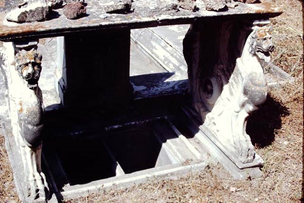 VI.9.2 Pompeii, 1968.  
Room 2, looking west. Below the table was a small tub/basin with two compartments located between the table legs. 
On the inside of both legs was a roundel with the bust of a cupid in the centre.  Photo by Stanley A. Jashemski.
Source: The Wilhelmina and Stanley A. Jashemski archive in the University of Maryland Library, Special Collections (See collection page) and made available under the Creative Commons Attribution-Non-Commercial License v.4. See Licence and use details.
J68f1000
In the foreground under the table 6 are two square marble recesses 7. According to Overbeck and Mau these were for cooling bottles.
See Overbeck J., 1884. Pompeji in seinen Gebäuden, Alterthümen und Kunstwerken. Leipzig: Engelmann, p. 308.