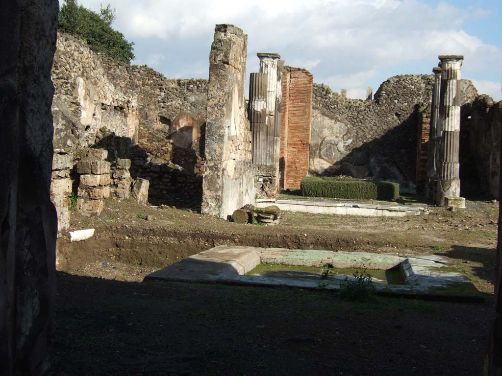VI.9.3 Pompeii. December 2005. Looking east across atrium 4 towards north-east corner, from entrance.
Room 7, at the rear on the left, had a niche/recess in its north-east corner.
Room 6, the tablinum can be seen in the centre.