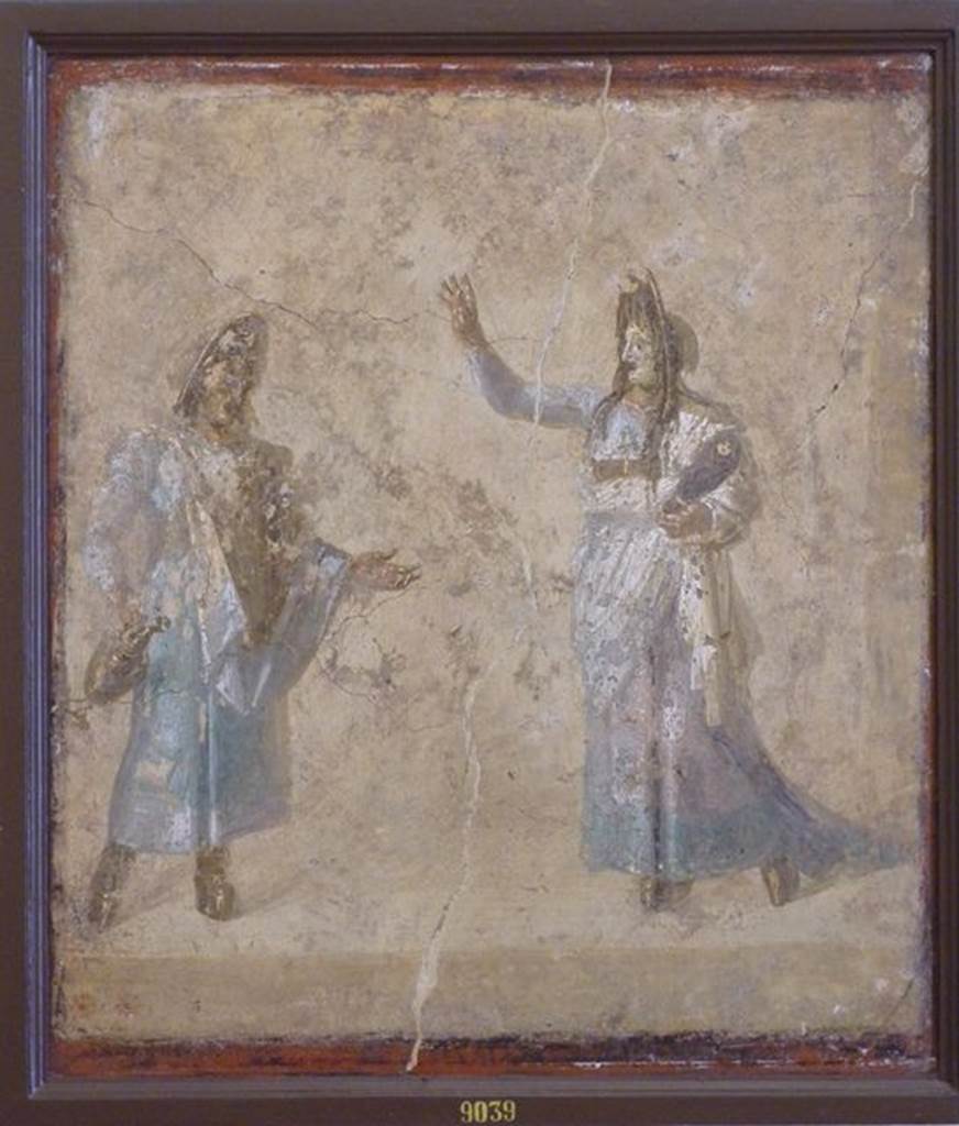 VI.9.6 Pompeii. Found on 1st July 1828 in room176, the west wall of the pseudo- peristyle.
Wall painting of masked actors possibly performing the myth of Auge because of the swaddled baby (Telephus?) in the arms of the woman.  Now in Naples Archaeological Museum. Inventory number 9039. See Helbig, W., 1868. Wandgemälde der vom Vesuv verschütteten Städte Campaniens. Leipzig: Breitkopf und Härtel. (1465).
