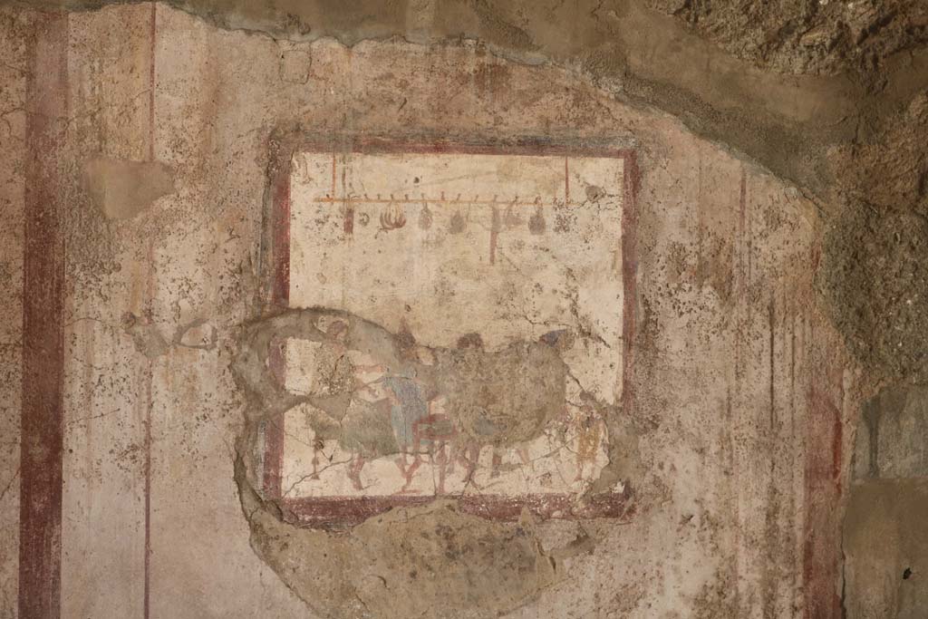 VI.10.1 Pompeii. December 2018. 
Fresco on south wall of rear room showing people at a table with sausages, onions and other food hanging above them.
Photo courtesy of Aude Durand.