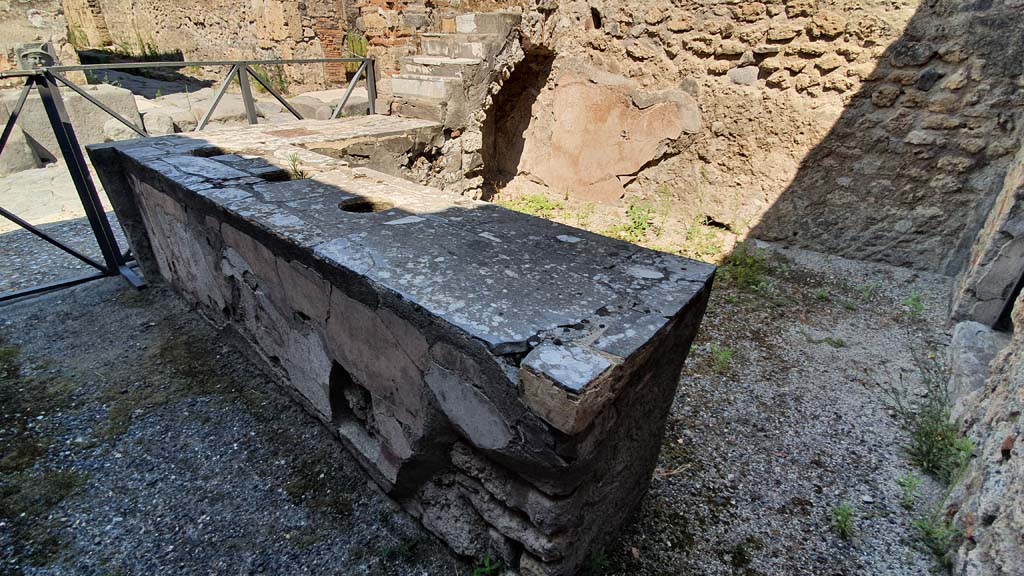VI.10.1 Pompeii. July 2021. 
Looking north-west across counter with three inset urns, towards display shelving and recess in north-west corner of bar-room.
On the left, on the other side of Via di Mercurio, is the fountain of Mercury outside VI.8.24.
Foto Annette Haug, ERC Grant 681269 DÉCOR.