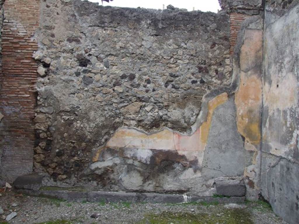VI.10.11 Pompeii. March 2009. Room 8, north wall of tablinum.  The tablinum was found with a large threshold of lava below a walled-up doorway. The middle zone of the wall had been painted with yellow panels separated by red partitions. In the centre of the north wall, the black predella was found with painted seahorses and green dolphins.
See Bragantini, de Vos, Badoni, 1983. Pitture e Pavimenti di Pompei, Parte 2. Rome: ICCD. (p.235, tablino 15)