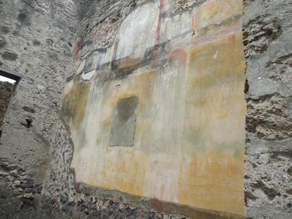 VI.10.11 Pompeii. March 2009. Room 16, painted plaster on west wall of oecus. The dado was unpainted being in preparation for a marble facing. The central panel of the middle zone was yellow with a central painting showing a Maenad and Satyr in flight. The central wall painting has been removed, and is now in Naples Archaeological Museum. The side panels were also yellow and contained medallions, now faded, separated by architecture on a white background. On the upper wall, there are the remains of a painted aedicula with figures of Satyr and Dionysus.
See Bragantini, de Vos, Badoni, 1983. Pitture e Pavimenti di Pompei, Parte 2. Rome: ICCD. (p.236, oecus 22)