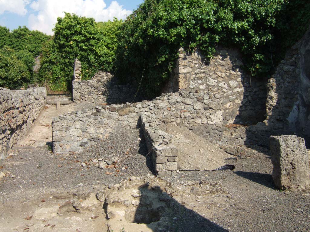 VI.11.4 Pompeii. September 2005. Looking east towards corridor leading to VI.11.17, on the left.
On the right is a room (5) in the south-east of the yard. The remains of a wall and hole for cistern can be seen in the lower centre.