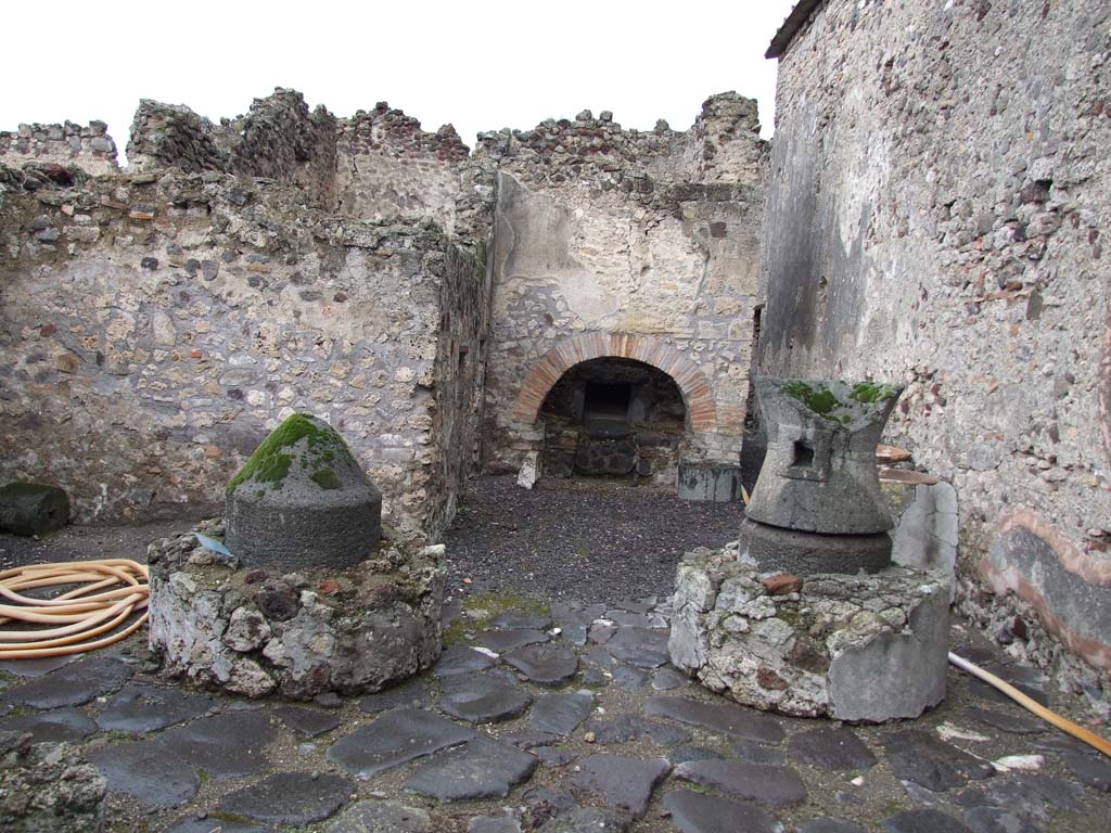 VI.11.9 Pompeii. December 2006. Room 16, mills in small bakery with oven 55 at rear.
