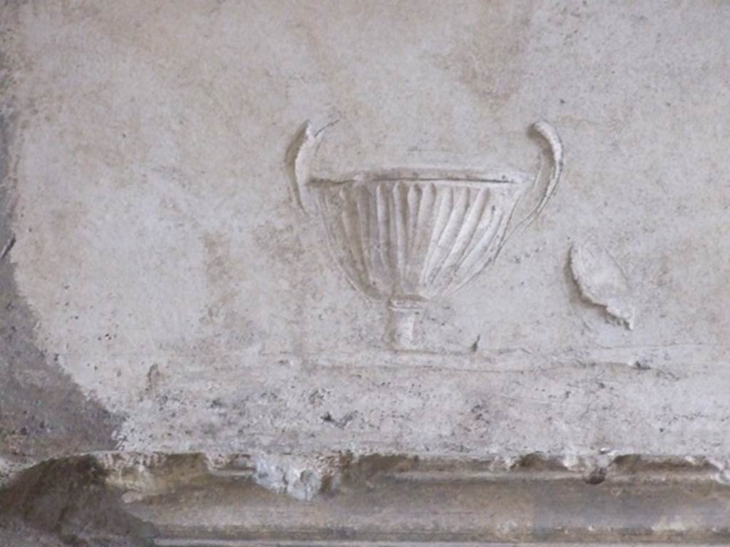 VI.11.9 Pompeii. December 2006. Room 21, detail in stucco of urn or cup on south end in arch of tepidarium.