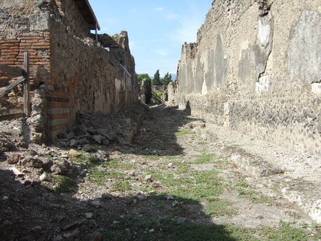 VI.9 Pompeii.         Vico del Fauno looking North         Side wall of VI.11.9