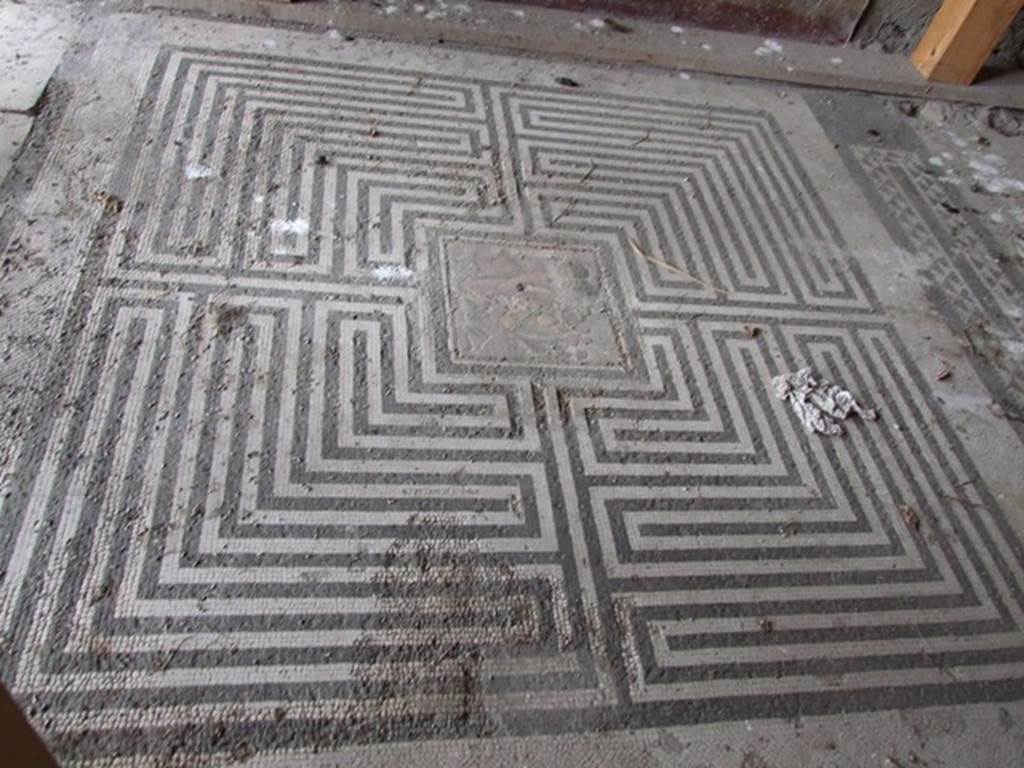 VI.11.10 Pompeii. December 2006. Room 42, labyrinth mosaic on floor of exedra.
According to Fiorelli, in PAH, vol. II, 1819-1860; 
“9th September 1835 – we are working to clear out the earth that covered all the floorings of the peristyle of the house of the private Baths, where in the floor of one of the rooms at the head of the same was revealed a small square of mosaic showing Theseus having killed the Minotaur, sized 17.25 inches squared (0.44m squared) (pal. 1 2/3 in quadro).”