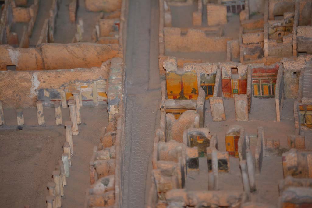 VI.11.9/10 Pompeii. July 2017. Looking west along Vicolo del Mercurio, with VI.12, House of the Faun, on left.
On the right is the south-west corner of atrium 3 (of VI.11.9), with the west wall of the entrance corridor, just visible.
In the corner is the west wall of room 5, with room 4 next to it. 
The doorway to room 6 leads into the room with red/yellow/green west wall, followed by west ala 7. 
Room 8, the area under the stairs, is the undecorated area next to it. 
From cork model in Naples Archaeological Museum.
Foto Annette Haug, ERC Grant 681269 DÉCOR.