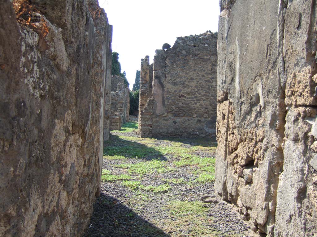 VI.11.13 Pompeii. September 2005. Looking west towards atrium, from entrance corridor.
According to Jashemski, a passageway in this house (excavated in 1842) led from the atrium to an open area on the right in which there was a cistern head.  
Such an area would normally be a garden but, since Fiorelli on the basis of numerous graffiti identified this site as the home and workshop of a producer of sailors clothing, the garden may have been used for other purposes.
See Jashemski, W. F., 1993. The Gardens of Pompeii, Volume II: Appendices. New York: Caratzas. (p.144)
For list of graffiti, see below.