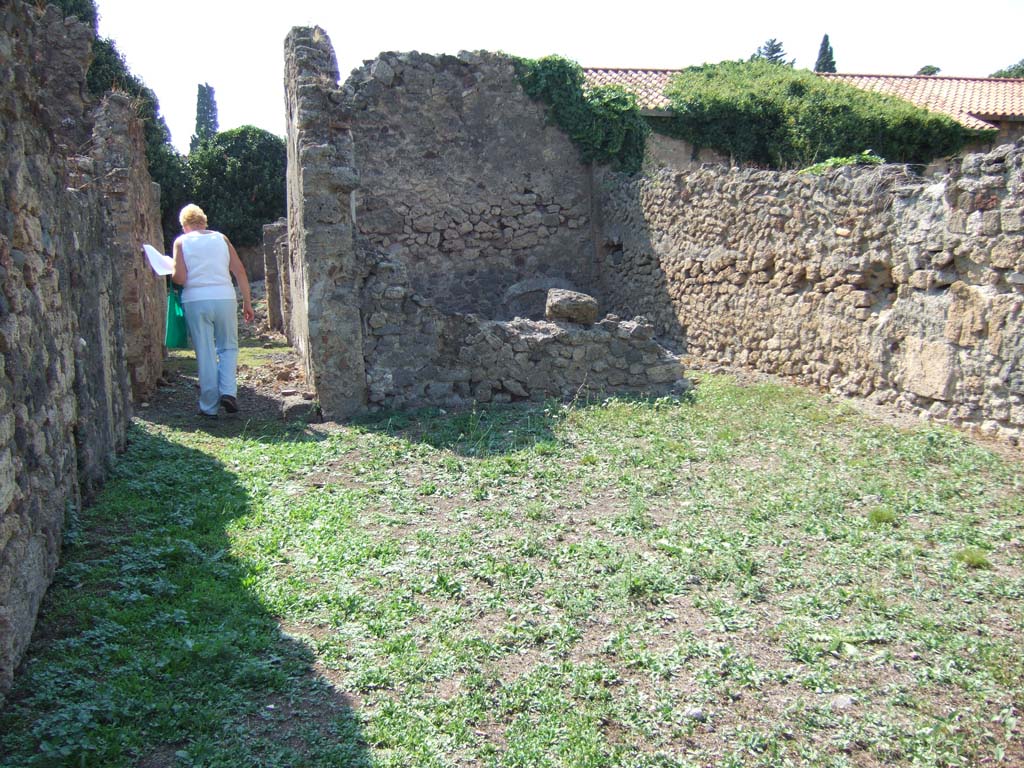 VI.11.13 Pompeii. September 2005. Looking west across open area, on the right in which there is a cistern head.  
The corridor ahead would have led to VI.11.6.