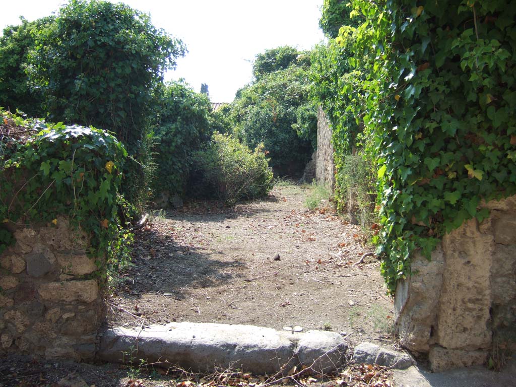 VI.11.17 Pompeii. September 2005. Entrance doorway, looking west.
According to Fiorelli, this entrance doorway of the house was linked to the workshop that had its doorway in the western vicolo at number 4.
See Pappalardo, U., 2001. La Descrizione di Pompei per Giuseppe Fiorelli (1875). Napoli: Massa Editore. (p.70)
According to Jashemski, the portico of the peristyle garden (on the left of entrance doorway at 17) was supported on the north and west by columns. These were connected by a low wall.
She said that Fiorelli incorrectly called this area a triclinium.
See Jashemski, W. F., 1993. The Gardens of Pompeii, Volume II: Appendices. New York: Caratzas. (p.143)
See Pappalardo, U., 2001. La Descrizione di Pompei per Giuseppe Fiorelli (1875). Napoli: Massa Editore. (p.69)