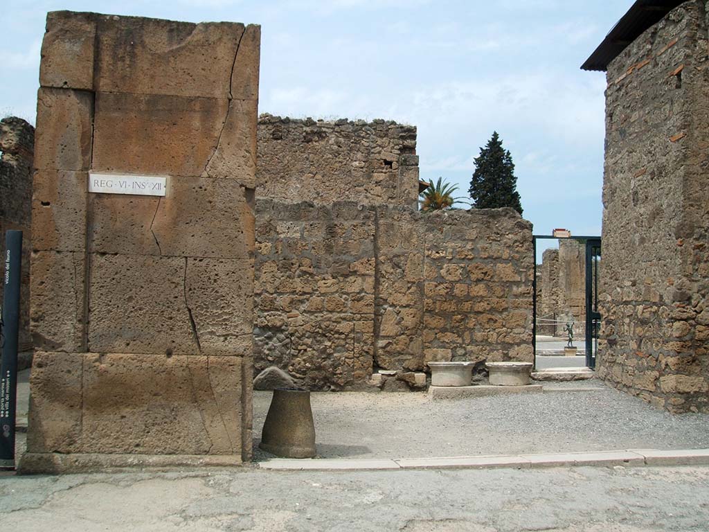 VI.12.1 Pompeii. May 2005. Shop entrance doorway, looking north.  
According to Fiorelli, found painted on the first corner pilaster, on the left, were the remains of an “Eituns”, or Oscan inscription.
Only a few letters were still visible.
See Pappalardo, U., 2001. La Descrizione di Pompei per Giuseppe Fiorelli (1875). Napoli: Massa Editore. (p.71)
See Antonini, R., in Quaderni Di Studi Pompeiana, 1/2007, Assoc. Int. Amici di Pompei, p. 57-73.