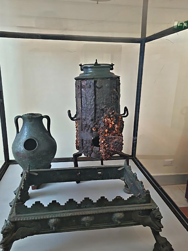 VI.12.2 Pompeii. September 2024. 
Display case with items – Portable bronze brazier, Stove and bronze chafing dish.
Now in Naples Archaeological Museum. Photo courtesy of Giuseppe Ciaramella.