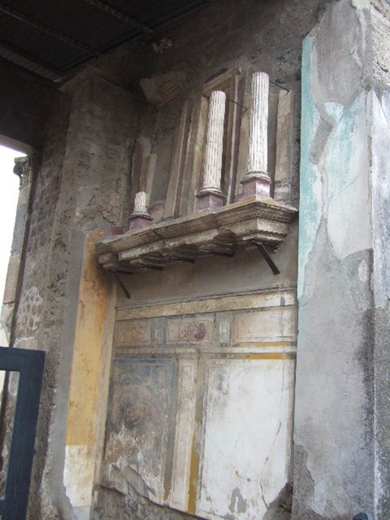 VI.12.2 Pompeii. December 2005. Entrance fauces. West wall with shelf,  on which is placed a façade with small columns.