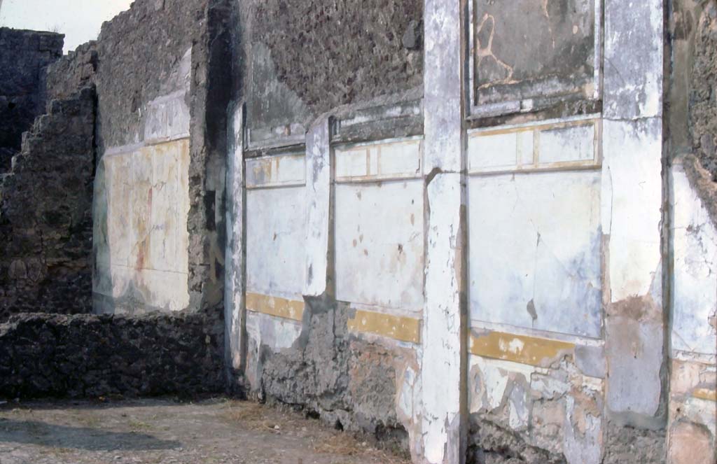 VI.12.2 Pompeii. 7th August 1976. Looking south-west across west exterior wall of middle peristyle and towards one of two dining rooms (on left).
Photo courtesy of Rick Bauer, from Dr George Fay’s slides collection.