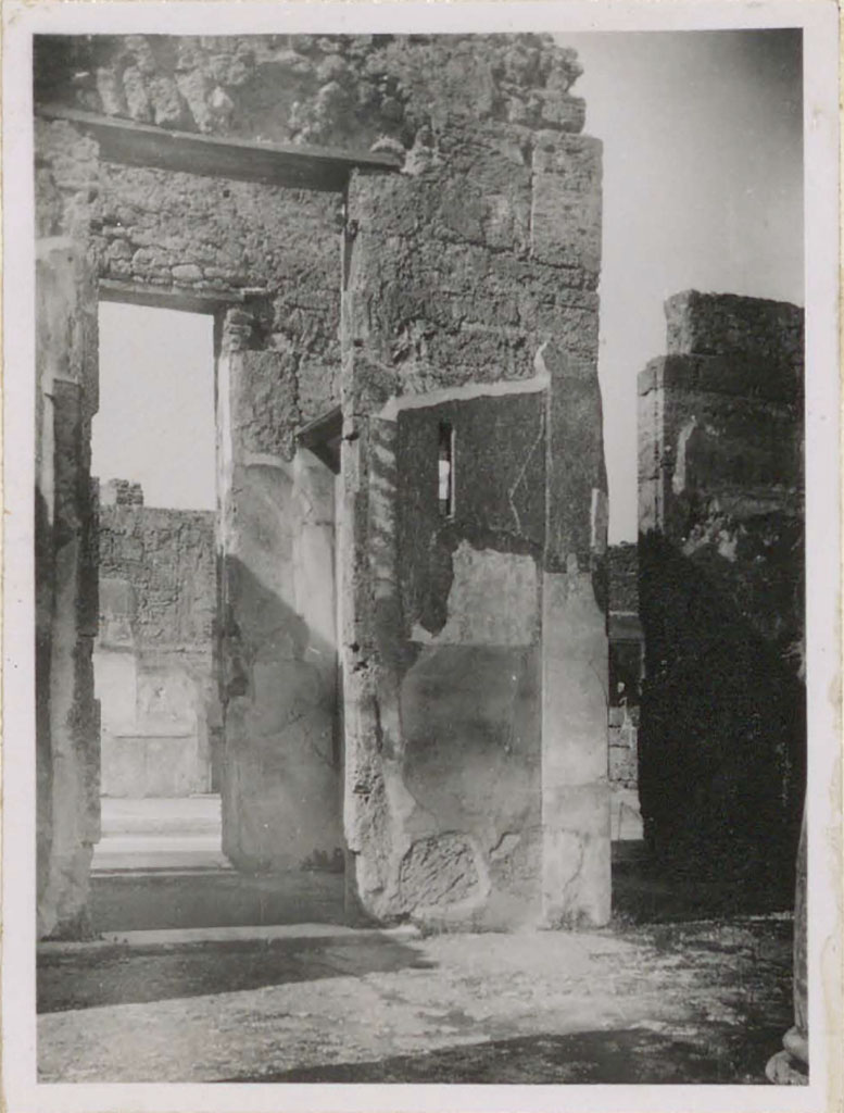 VI.12.5 Pompeii. Pre-1943. West side of tetrastyle atrium 7. (On the right is the west ala 11.) 
Looking west from Tetrastyle atrium towards doorway of room 10 that also served as a passageway between the two atriums.
In this room, there was a rare example of a perfectly preserved interior window with a piece of glass.
(In camera che serviva di passaggio fra i due atri, (attraversa la seconda porta si vede la parete del cubicolo no.17 – sul lato occidentale dell’atrio toscanico) – vi era un raro sempio di una finestra interna perfettamente conservata con un pezzo di vetro.)
See Warscher, T. (1946). Casa del Fauno, Swedish Institute, Rome. (p.58, n.83).
According to Garcia y Garcia, in his description of fig. 162 on p.84, same photo as above -he says –
“Atrio tetrastilo, lato occidentale prima del bombardamento: la finestrella a destra dell’ingresso era dotato da vetro al momento dello scavo.”(Foto T. Warscher).
(“Tetrastyle atrium, west side before the 1943 bombing: the small window on the right of the entrance was equipped with glass at the time of excavation”.)
See Garcia y Garcia, L., 2006. Danni di guerra a Pompei. Rome: L’Erma di Bretschneider. (p.84, fig.162).