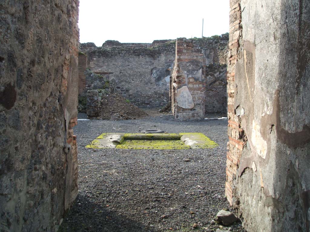 VI.13.10 Pompeii. December 2004. Looking west from entrance corridor across atrium and impluvium. 
According to Garcia y Garcia, at the head of the impluvium was a masonry table with an arch below.
This suffered damage to its top, when the bomb fell on the area of the house at VI.13.9, in 1943.
See Garcia y Garcia, L., 2006. Danni di guerra a Pompei. Rome: L’Erma di Bretschneider. (p.87 and figs 186 and 187)
Fig 187 shows the table, photographed by Tatiana Warscher after the war.
It appears to have suffered a further loss and is now no longer there!