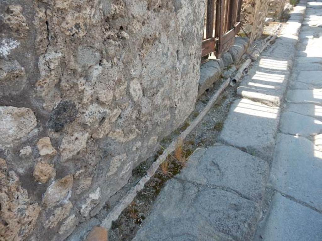 VI.13.13 Pompeii. May 2015. Vicolo dei Vettii outside entrance doorway, showing lead pipes in pavement. Photo courtesy of Buzz Ferebee.