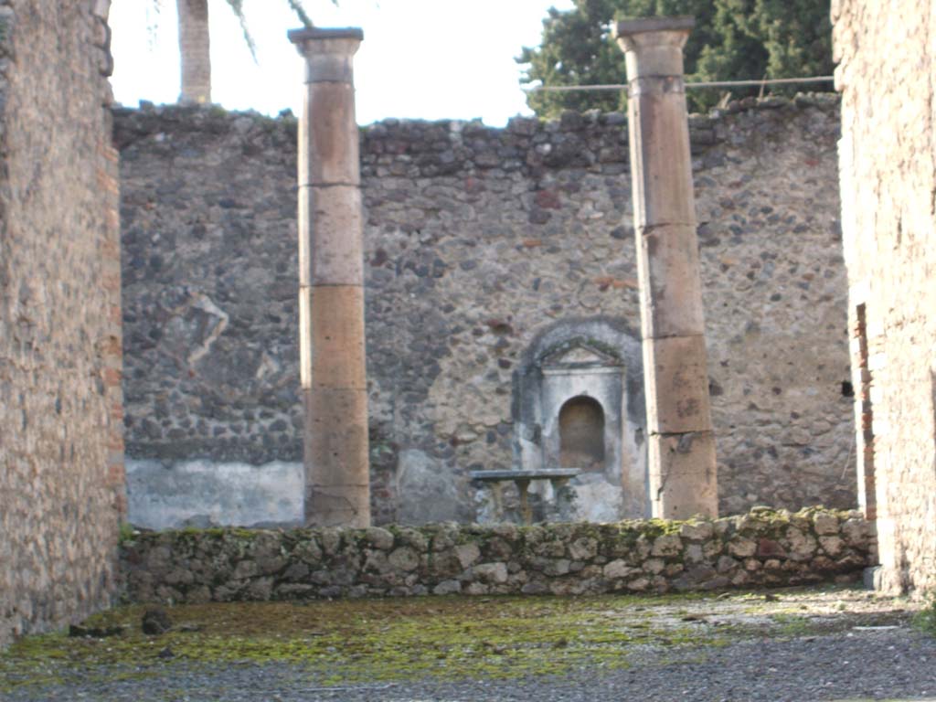 VI.13.13 Pompeii. December 2004. Looking west across tablinum towards peristyle and garden.
According to Boyce, against the west wall of the peristyle stands a simple aedicula.
Above a base two side walls support a roof with small pediment, protecting a vaulted niche.
The whole structure is coated with a layer of white stucco.
See Boyce G. K., 1937. Corpus of the Lararia of Pompeii. Rome: MAAR 14. (p.52, no.195, and Pl.35,4).