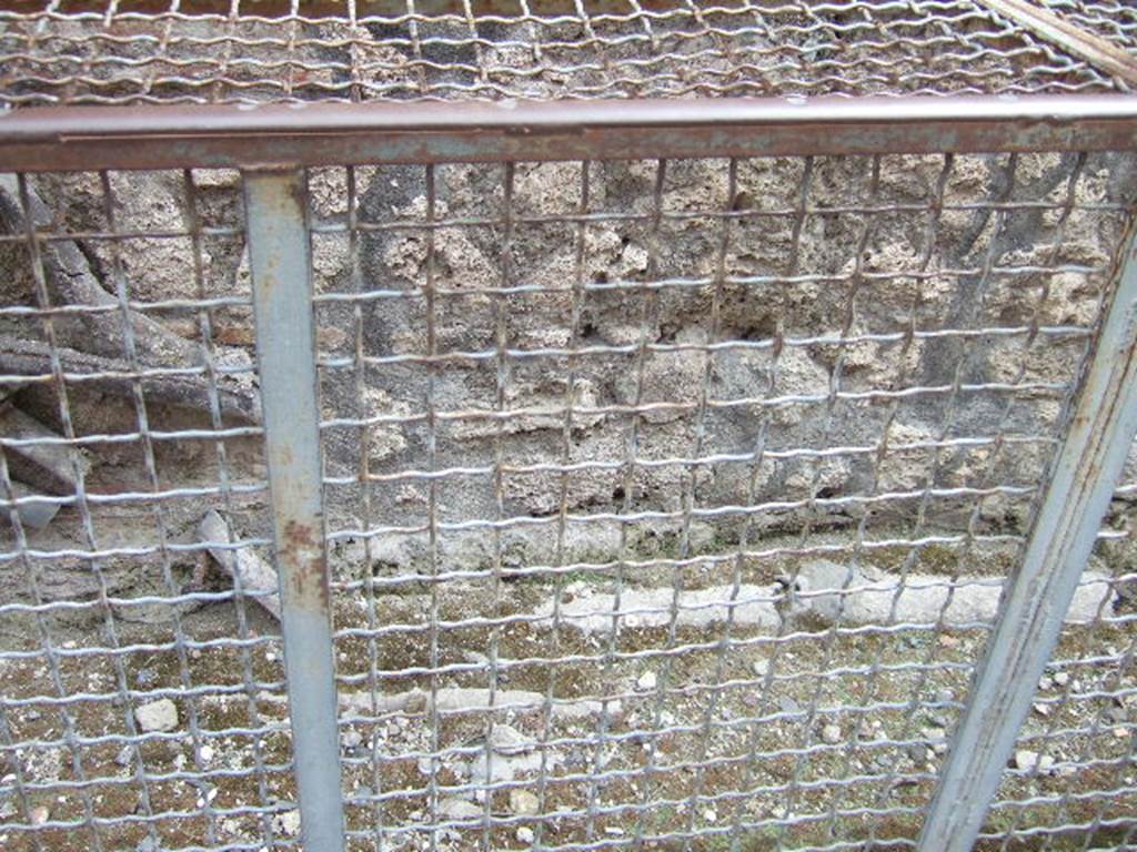 VI.13.16 Pompeii. May 2006.  Lead pipes on back wall of VI.13.16, and in pavement on Vicolo di Mercurio.
