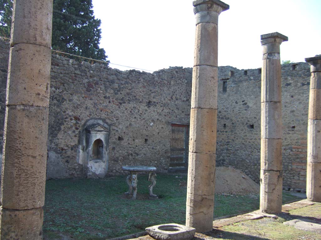 VI.13.18 Pompeii. September 2005. Looking west across peristyle garden.
According to Jashemski, the garden was enclosed by a portico on the south and east side.
It was supported by six columns and one engaged column.
An aedicula shrine stood against the west garden wall.
In the middle of the garden was a round marble table with three legs.
The upper part of the legs represented the head of a wild animal rising out of a leafy ornament.
The lower part was of the feet of a lion or leopard.
The puteal, a very old one, came into view during the 1943 bombing.
This also made it possible to measure the cistern, which is about two metres deep.
See Jashemski, W. F., 1993. The Gardens of Pompeii, Volume II: Appendices. New York: Caratzas, (p.147-48).