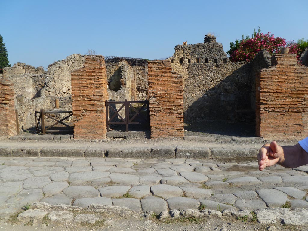 VI.14.5 Pompeii, in centre. July 2010. Looking north across Via della Fortuna. 
On the left is VI.14.4, on the right is VI.14.6. Several down pipes can be seen in the photo. Photo courtesy of Michael Binns.