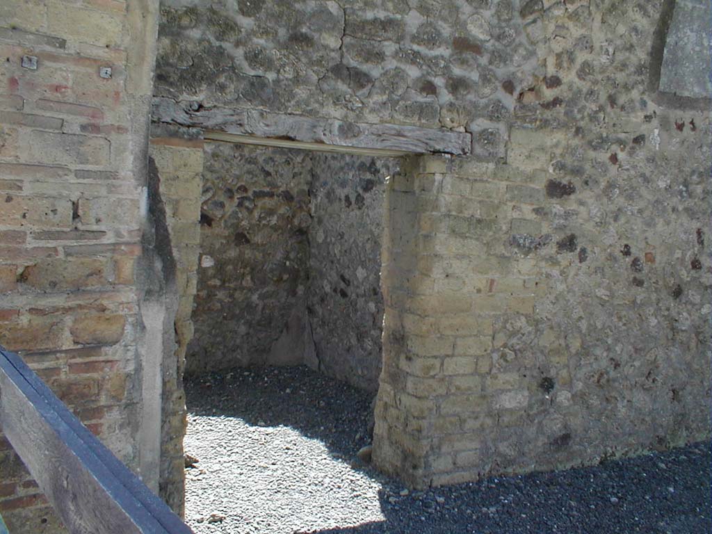 VI.14.28 Pompeii. May 2005. Doorway to room in south wall.
According to BdI, on the ground floor was a main room, with a small room on the south side.
The small room had a window onto the roadway.
Also found in the small room were two paintings, hardly recognisable. 
However, in one a man lying on a bed could be recognised.
See Bullettino dell’Instituto di Corrispondenza Archeologica (DAIR), 1876, (p.50)