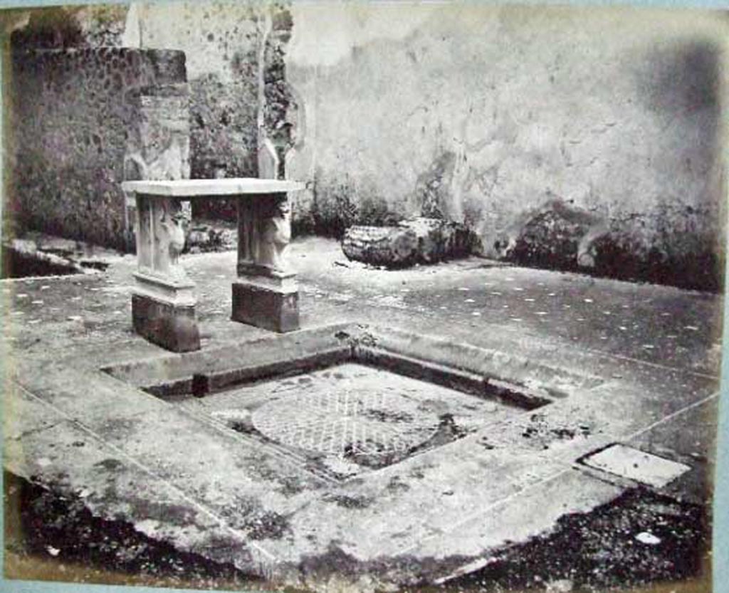 VI.14.39 Pompeii. Casa Lucrum Gaudium or Officina di tornitore. 
Looking south-east across atrium and tablinum, showing how it looked before bombing in 1943.
Old undated photograph courtesy of the Society of Antiquaries, Fox Collection.
According to Mau in BdI, the floor of the atrium was made of opus Signinum with crushed lava.
Near to the impluvium was a vent covered by a piece of square stone.
The rim of the impluvium was made of the same opus Signinum as the atrium floor, but with white stones.
In the front rim, between a line of white stones that surrounded it, one could read in letters not very regular, the words – LVCRVM GAVDIVM
At the rear were the two table legs, supported on a brick base which was painted red (0.25 high).
The base of each leg was marble and shaped like a griffin with a lion’s head.
See Mau in Bullettino dell’Instituto di Corrispondenza Archeologica (DAIR), 1878, (p.90).