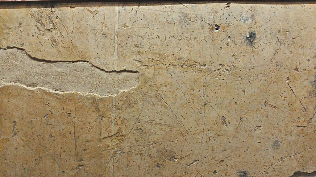 VI.14.43 Pompeii. 
Graffiti from wall next to main entrance of the house. Now in Naples Archaeological Museum, inv. 4685. Photo courtesy of Giuseppe Ciaramella.
According to the information description card in Naples Museum –
Plaster fragment with scratched letters, reading –
“Here and now I copulated with a girl who is beautiful go look at and praised by many, but inside she was nothing but filth”.
(“Qui e ora ho scopato una ragazza bella d’aspetto, da molti lodata, ma dentro era soltanto fango”.)
