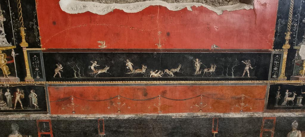 VI.15.1 Pompeii. January 2023.
East wall with painted panel of cupids in a race between chariots pulled by deer. Photo courtesy of Miriam Colomer.