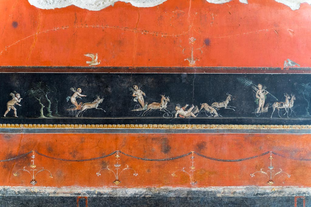 VI.15.1 Pompeii. March 2023.
Detail of part of central painted panel of cupids in a race between chariots pulled by deer. Photo courtesy of Johannes Eber.