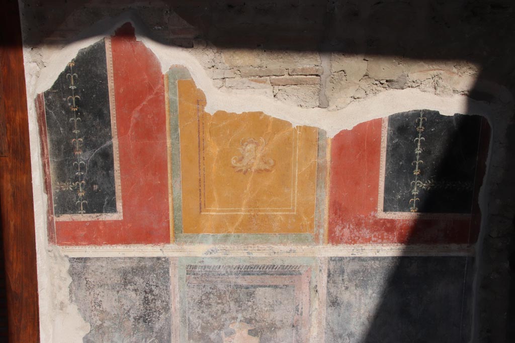 VI.15.1 Pompeii. October 2023.
North portico, detail of painted decoration on east side of doorway to the “Cupids’ room”, (PPM - room q). Photo courtesy of Klaus Heese.