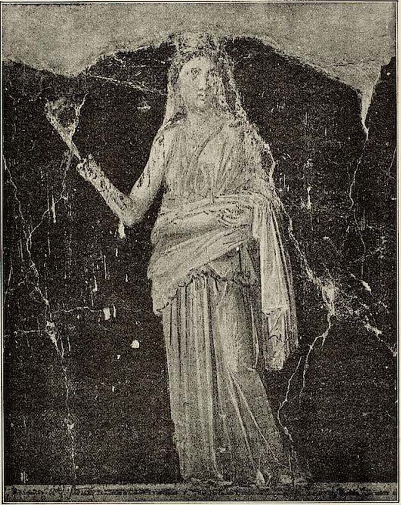 VI.15.1 Pompeii. Painted panel on zoccolo (0.50 high) from west wall at south end.
Described by Sogliano as –
“Figura muliebre, coronata di foglie e con un velo che le discende dall’occipite sulle spalle: indossando una veste paonazzo-chiaro, con manto giallognolo, tiene nella dritta una fiaccola, e con la sinistra sostiene, intorno ai lombi, una piega del manto.”
(A feminine figure crowned with leaves and with a veil descending from her head onto her shoulders: wearing a pale-purple robe, with a yellowish mantle, she holds a torch in her right hand, and with her left hand supports, around her waist, a fold of the mantle.)
See Sogliano, A. La Casa dei Vettii in Pompei Mon. Ant. 1898. (p.369-370, fig. 61).