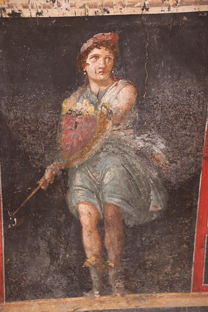 VI.15.1 Pompeii. October 2023.
Painting of Amazon holding axe and shield from zoccolo on lower west wall. Photo courtesy of Klaus Heese.