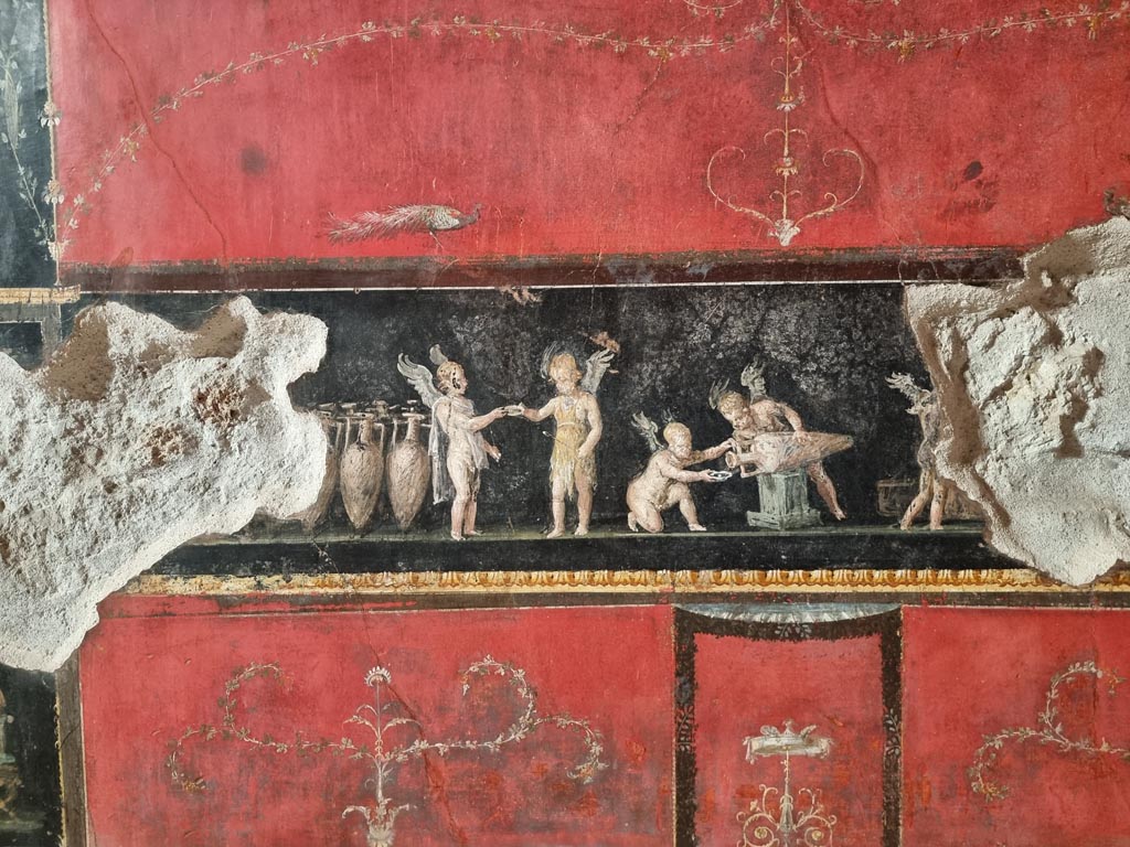 VI.15.1 Pompeii. January 2023.
Detail of painting on central panel in predella on west wall, with painting of cupids buying and selling wine. Photo courtesy of Miriam Colomer.