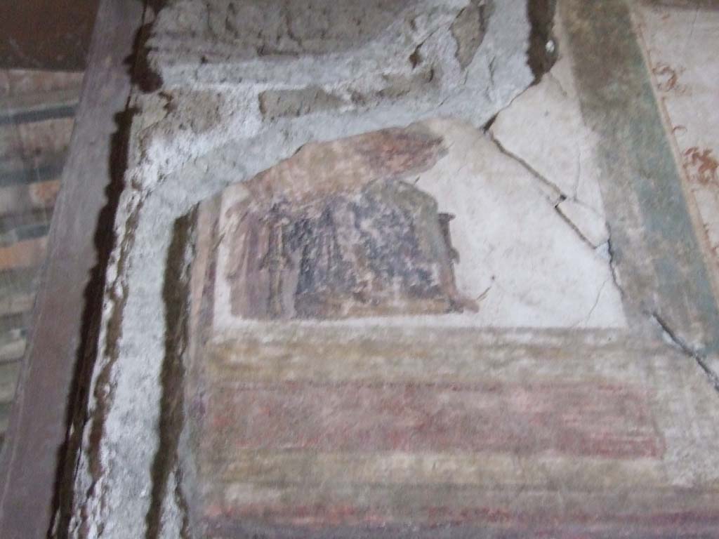 VI.15.1 Pompeii. December 2006. Detail of painting from upper north wall in oecus on south side of atrium.
According to Sogliano –
“The central prospective was cut by the entrance doorway: here one sees the lower part of a figure seated on a throne;
the upper part was bare and the legs were covered by a grey cloak.”
See Sogliano, A. c.1898. La Casa dei Vettii in Pompei Mon. Ant. 1898. (p.261/262).