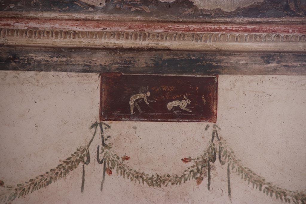 VI.15.1 Pompeii. October 2024. Painted panel from east wall at north end, above medallion. Photo courtesy of Klaus Heese.
