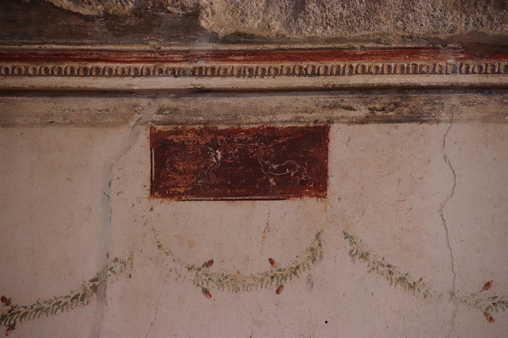 VI.15.1 Pompeii. October 2024. Detail of small painted panel at south end of west wall. Photo courtesy of Klaus Heese.