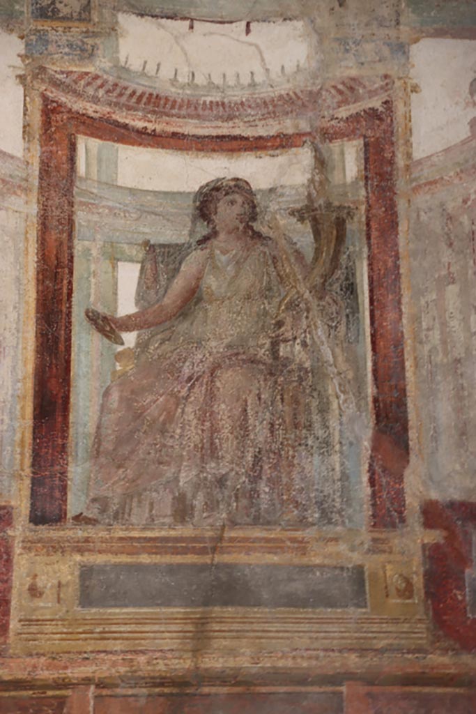 VI.15.1 Pompeii. October 2023.
Upper east wall of exedra, detail of painted figure in centre of wall. Photo courtesy of Klaus Heese.