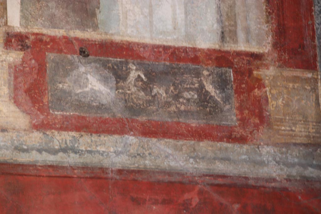 VI.15.1 Pompeii. October 2023.
Upper east wall of exedra, painted panel below figure at south end of east wall. Photo courtesy of Klaus Heese.