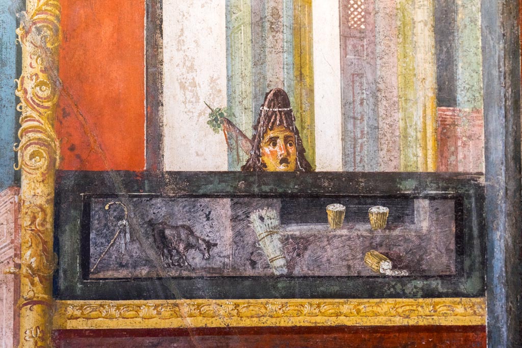 VI.15.1 Pompeii. March 2023.
Detail of panel from east wall at south end, with wall painting of drinks with mask above. Photo courtesy of Johannes Eber.