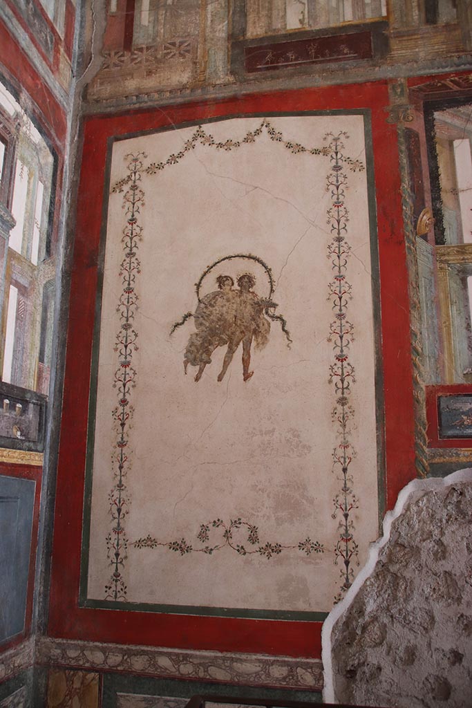 VI.15.1 Pompeii. October 2024.
South wall of exedra, in south-east corner, with painting of two floating figures.
Photo courtesy of Klaus Heese.