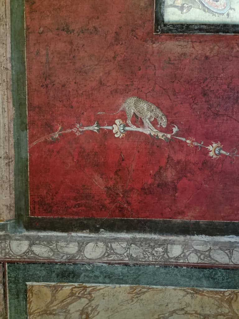 VI.15.1 Pompeii. December 2023.
South wall of exedra, detail of painted decoration below central panel. Photo courtesy of Miriam Colomer.