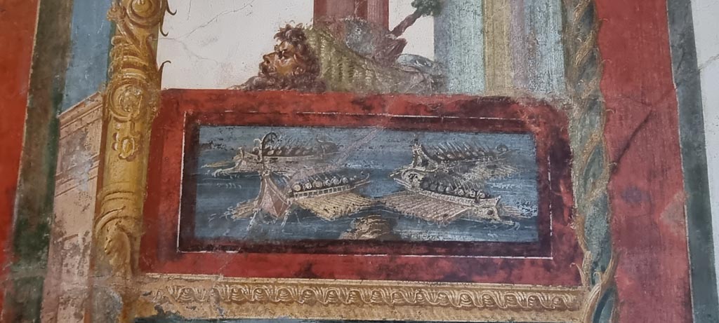 VI.15.1 Pompeii. January 2023.
Painted panel of naval scene on west side of central painting on south wall. Photo courtesy of Miriam Colomer.
