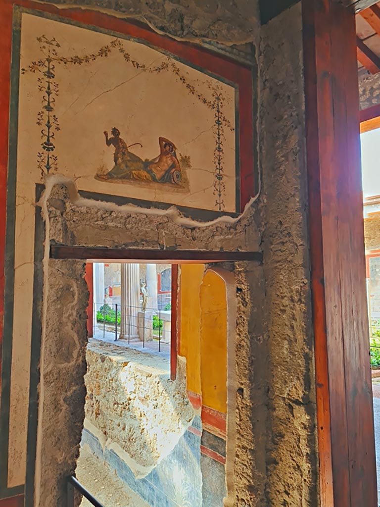 VI.15.1 Pompeii. April 2023.
South wall of exedra at west end, with doorway into north ala and window overlooking peristyle.
Photo courtesy of Giuseppe Ciaramella.