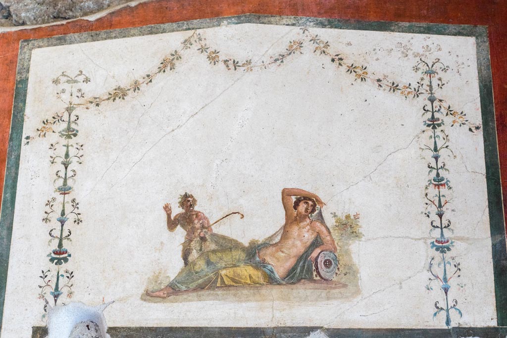 VI.15.1 Pompeii. March 2023.
Painting of Pan discovering Hermaphrodite over door in south wall of exedra. Photo courtesy of Johannes Eber.