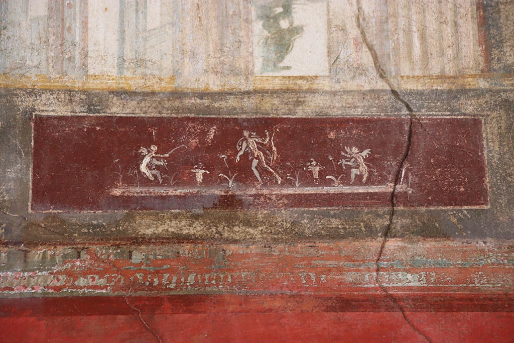 VI.15.1 Pompeii. October 2024.
Upper north wall of exedra, detail of painted figures on panel towards east end. Photo courtesy of Klaus Heese.