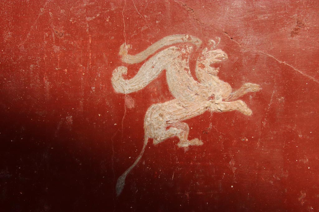 VI.15.1 Pompeii. October 2023.
North wall of small courtyard/peristyle garden “s”, detail of painted griffin from west end. Photo courtesy of Klaus Heese.