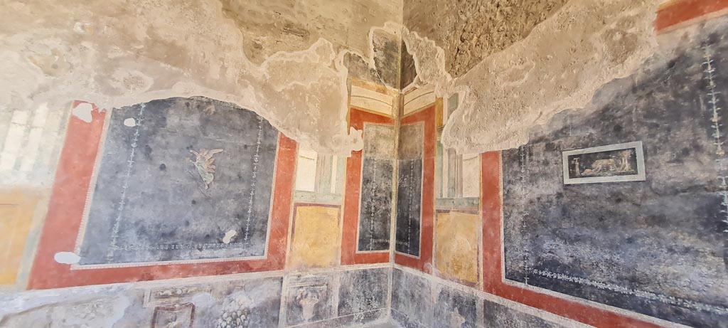 VI.15.1 Pompeii. April 2023.
Painted wall decoration in south-west corner, with west wall, on right. Photo courtesy of Giuseppe Ciaramella.